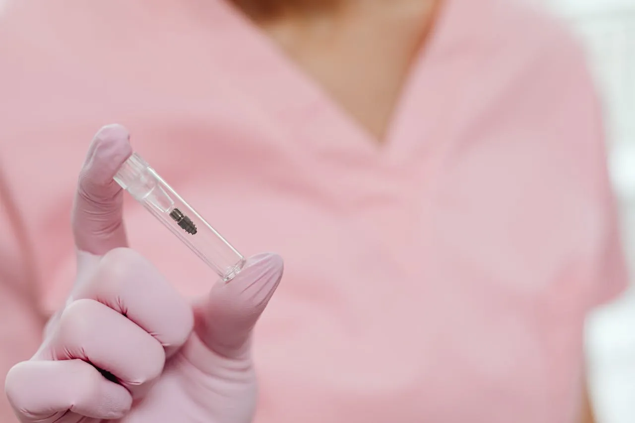 Dental professional holding a titanium implant post ready for surgical placement — the same Straumann system used at Taki Dent Antalya