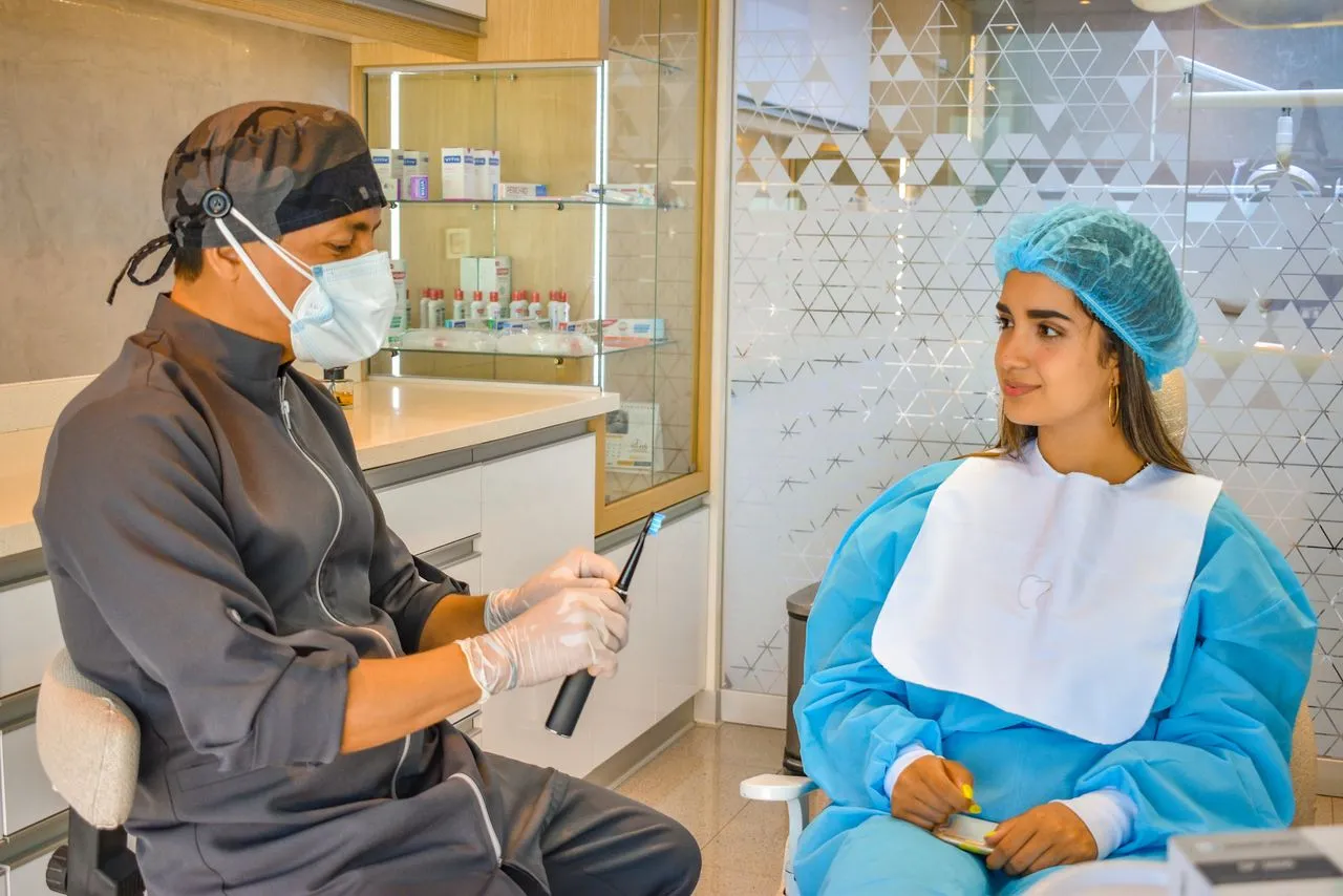 Dentist consulting with a patient at a desk — the first step of dental treatment planning at a top Turkish clinic in Antalya